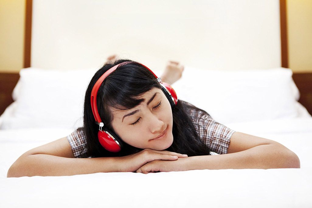ベッドで音楽を聴いている人