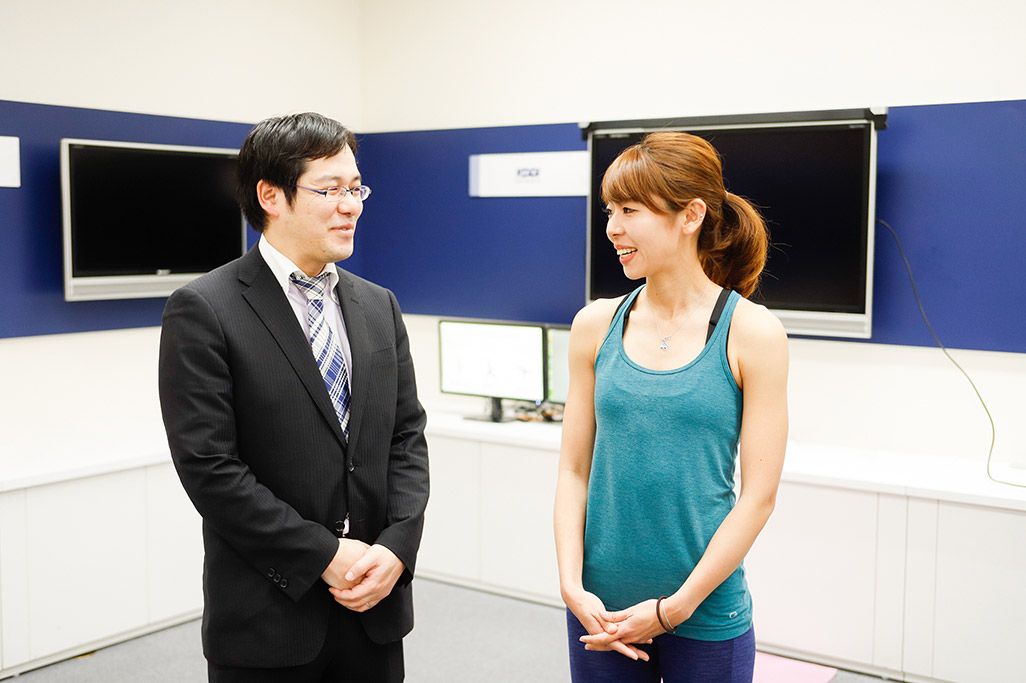 KDDI総合研究所の田坂和之とフィットネスインストラクターの浦谷美帆さん