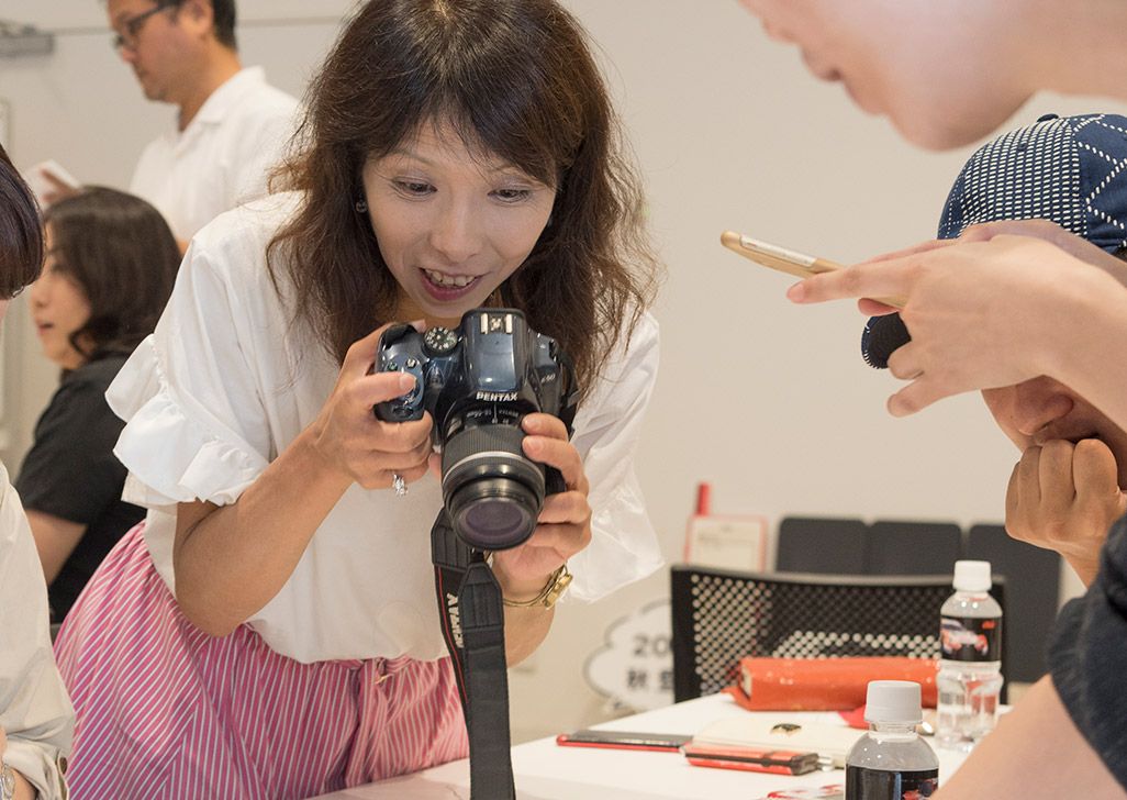 INFOBARファンミーティング新宿で披露されたINFOBAR xvのデザインモックを撮影する参加者