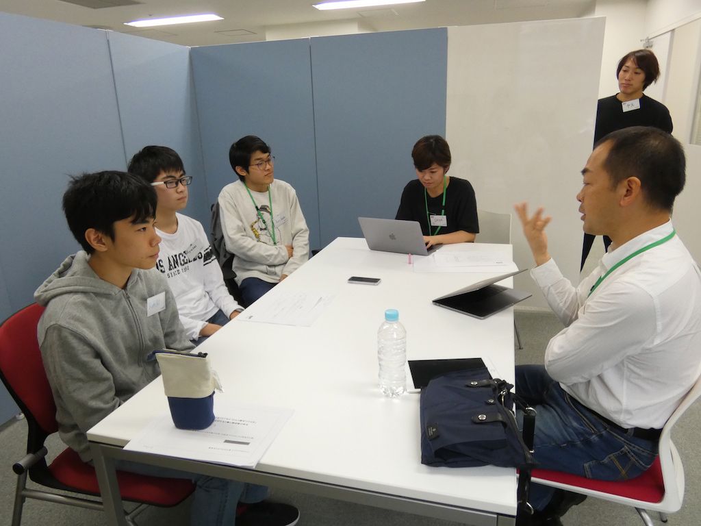 中学生たちのインタビューを受けるKDDIの新井田統