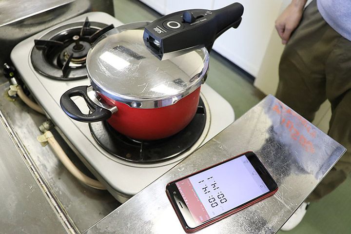 Silitの赤い圧力鍋の横に置かれたスマートフォンのタイマー