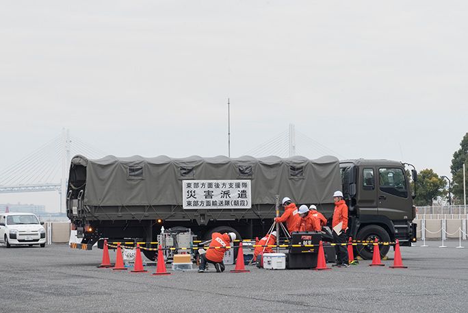KDDIの災害対策公開訓練にて、自衛隊と連携して可搬型基地局を運んで設営する