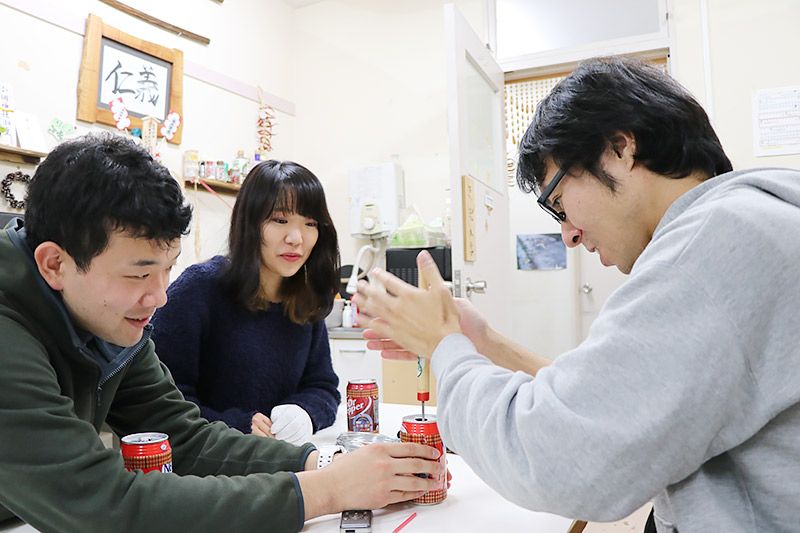 空き缶の上部に穴をあける地主
