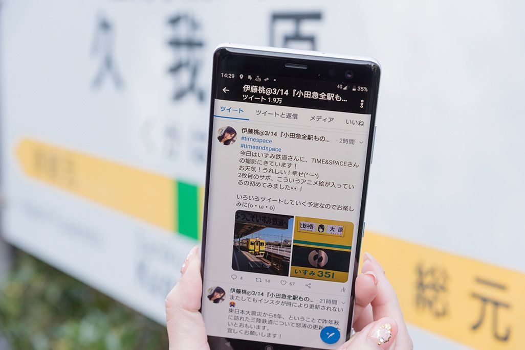 いすみ鉄道「久我原駅」の駅名標の前でツイートする伊藤桃