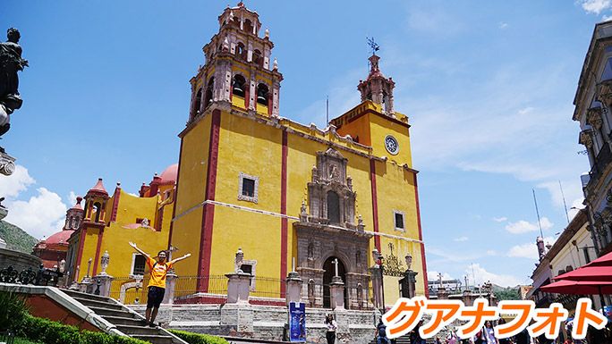 グアナフォトのカラフルな建物の前でポーズをする地主