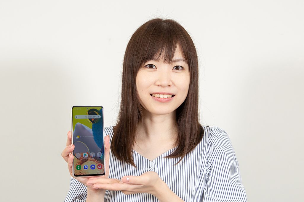 Galaxy A51 5Gを手に持ったKDDI広報部の女性