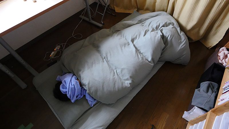 顔にタオルをかけて布団で眠る地主