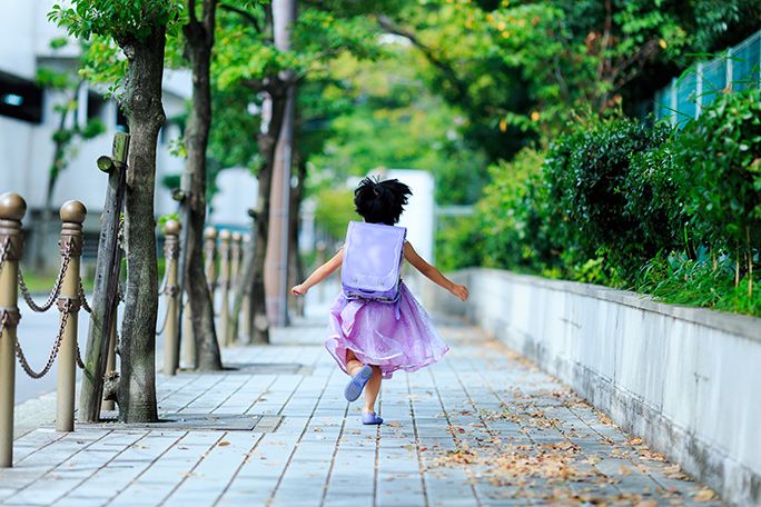 ひとりで学校へ向かうランドセルを背負った女の子