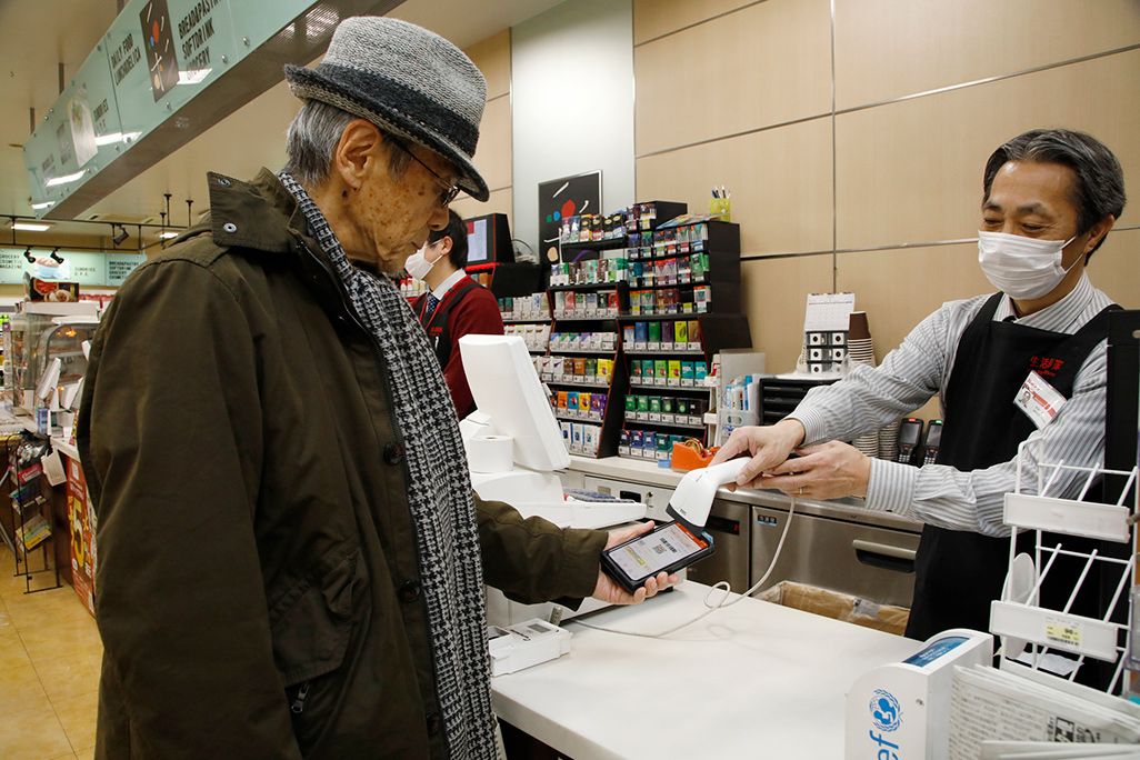 コンビニでau PAYで支払いしている様子