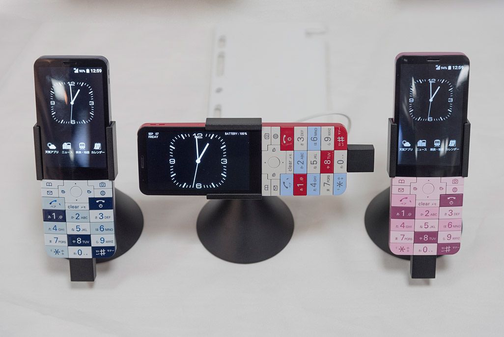 INFOBAR xvが3色勢ぞろい。中央が「置き時計モード」