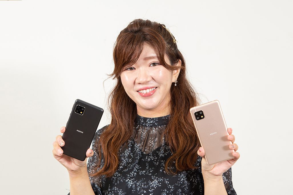AQUOS sense5Gを手に持ったKDDI広報部の女性