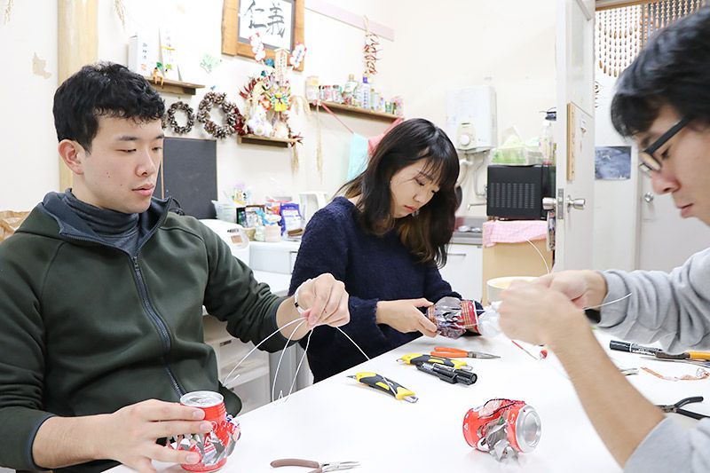 空き缶に針金を通す3名