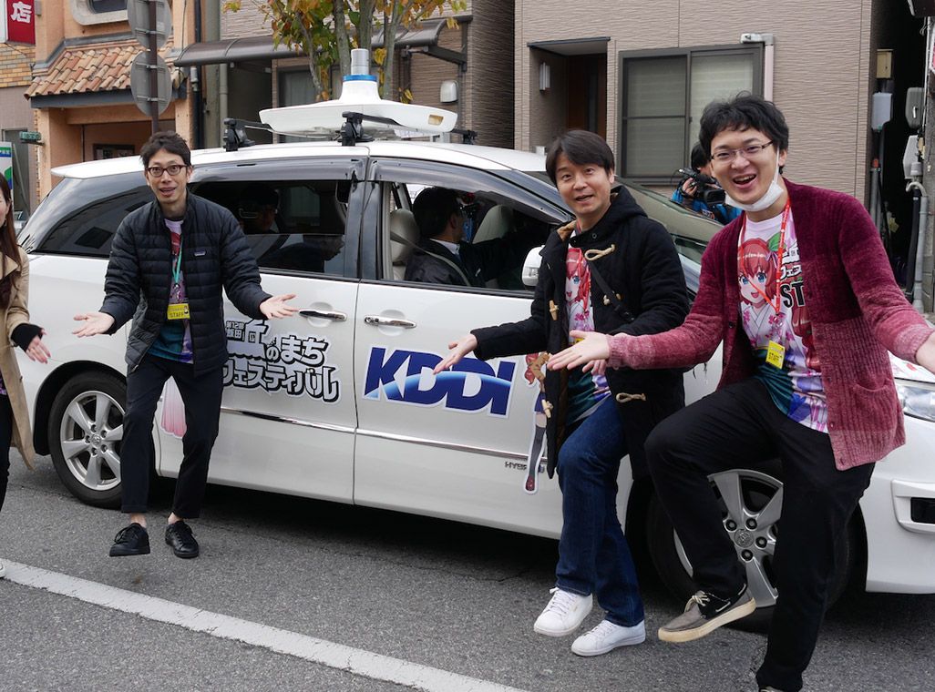 自動運転車の前でポーズをとるKDDIスタッフたち